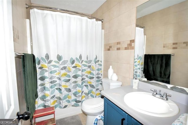 bathroom with toilet, shower / tub combo, vanity, and tile walls