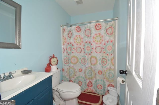 full bathroom featuring visible vents, toilet, vanity, and a shower with curtain