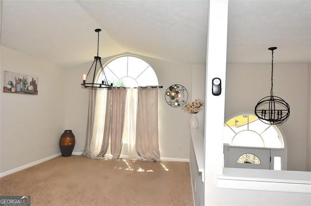 unfurnished dining area with an inviting chandelier, baseboards, lofted ceiling, and carpet floors