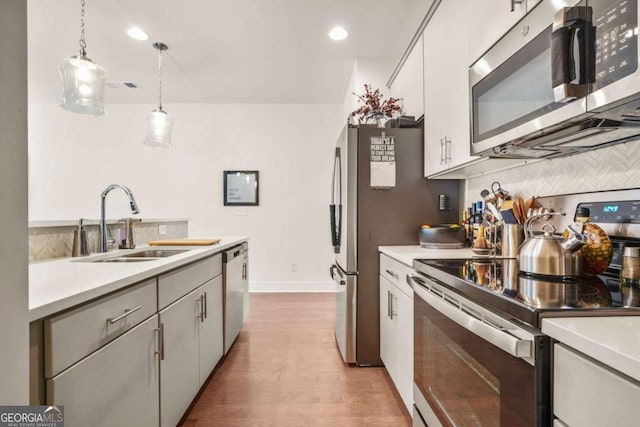 6322 Scudders Dr, Lithonia, GA 30058 - kitchen with stainless steel appliances, light countertops, wood finished floors, a sink, and tasteful backsplash