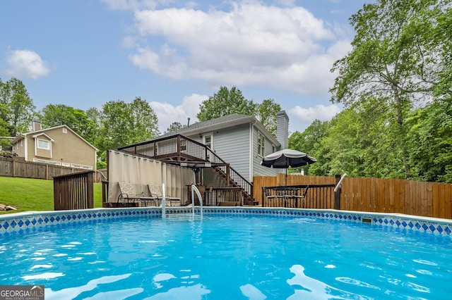 view of swimming pool with a fenced backyard, a fenced in pool, a deck, and stairway
