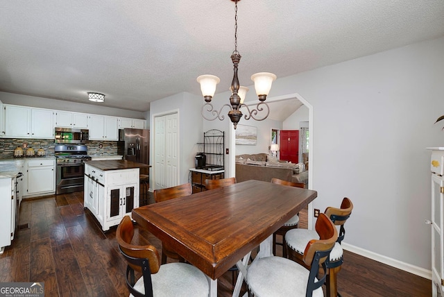 dining area featuring an inviting chandelier, arched walkways, a textured ceiling, baseboards, and dark wood-style floors