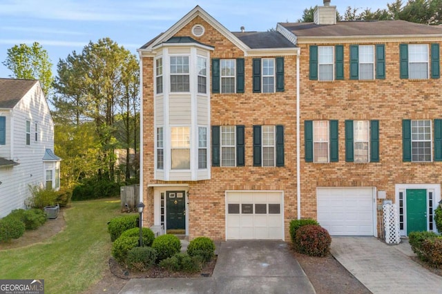 4366 Thorngate Ln, Acworth, GA 30101 - townhome / multi-family property featuring a front yard, an attached garage, a chimney, brick siding, and driveway