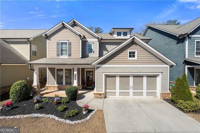 craftsman-style home with driveway, stone siding, and covered porch