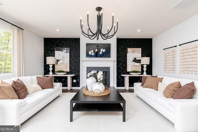 living room with an accent wall, a chandelier, a fireplace, visible vents, and recessed lighting