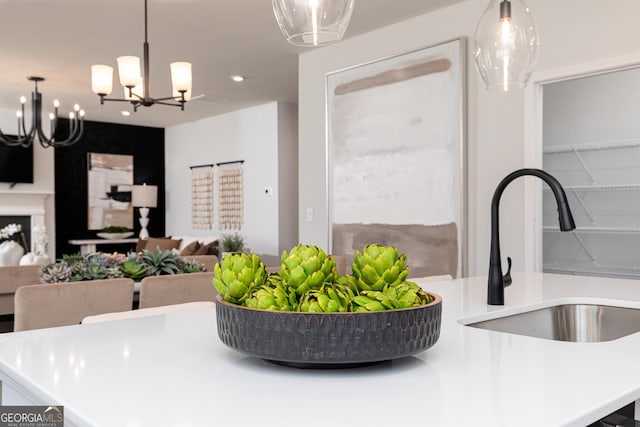 kitchen with a sink, open floor plan, a chandelier, light countertops, and decorative light fixtures