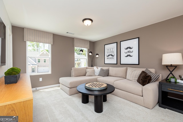 living area featuring baseboards, visible vents, and carpet floors