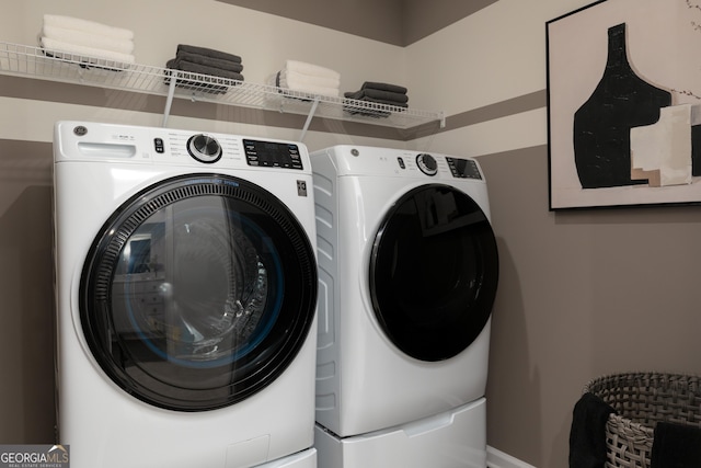 clothes washing area with washing machine and clothes dryer and laundry area