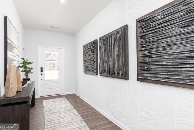 entryway featuring baseboards, visible vents, wallpapered walls, and dark wood-style floors