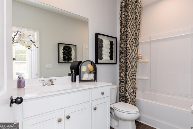 full bathroom with shower / bath combo, wood finished floors, toilet, and vanity