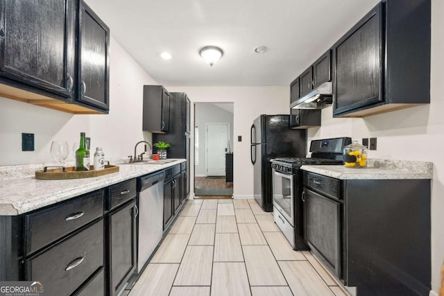 3690 Asbury Ln SW, Atlanta, GA 30331 - kitchen with stainless steel appliances, under cabinet range hood, light countertops, and dark cabinetry