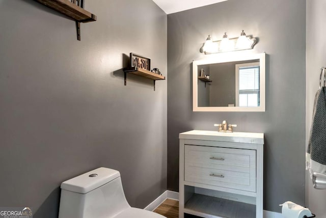 1055 River Bluff Dr, Winder, GA 30680 - bathroom with toilet, wood finished floors, vanity, and baseboards