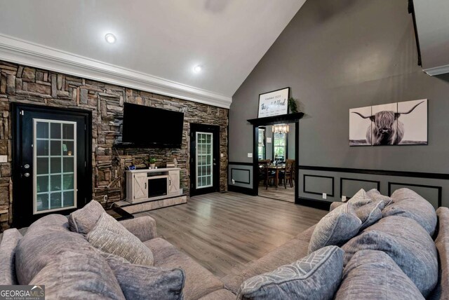 1055 River Bluff Dr, Winder, GA 30680 - living area featuring crown molding, high vaulted ceiling, a fireplace, a wainscoted wall, and wood finished floors