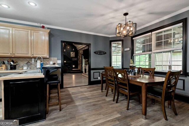 1055 River Bluff Dr, Winder, GA 30680 - dining area with wood finished floors, an inviting chandelier, and ornamental molding