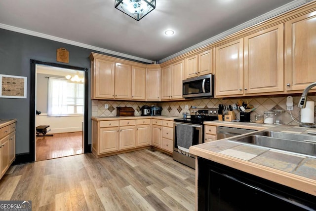 1055 River Bluff Dr, Winder, GA 30680 - kitchen featuring light brown cabinets, tile counters, crown molding, stainless steel appliances, and light wood finished floors