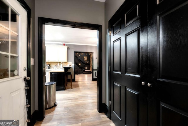 1055 River Bluff Dr, Winder, GA 30680 - hallway featuring light wood-style flooring, crown molding, and stairs
