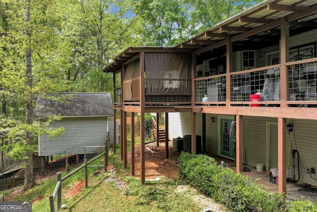 1055 River Bluff Dr, Winder, GA 30680 - rear view of house with a sunroom, a shingled roof, and central air condition unit