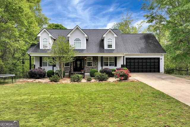 1055 River Bluff Dr, Winder, GA 30680 - cape cod house with a trampoline, driveway, an attached garage, a front lawn, and a porch