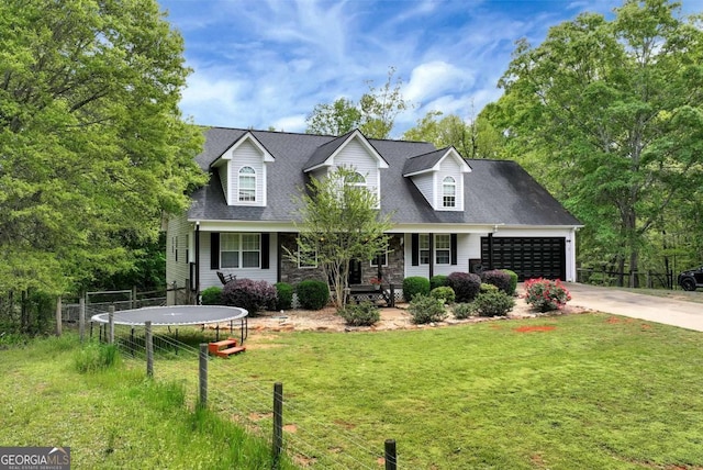 1055 River Bluff Dr, Winder, GA 30680 - cape cod home featuring a front yard, an attached garage, a trampoline, stone siding, and concrete driveway
