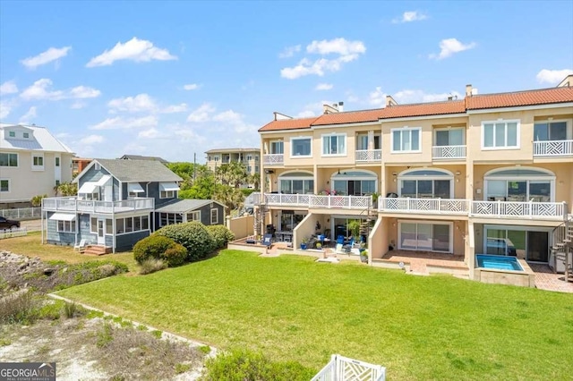 back of property featuring a lawn and stucco siding