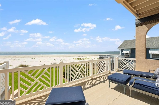balcony with a water view and a view of the beach