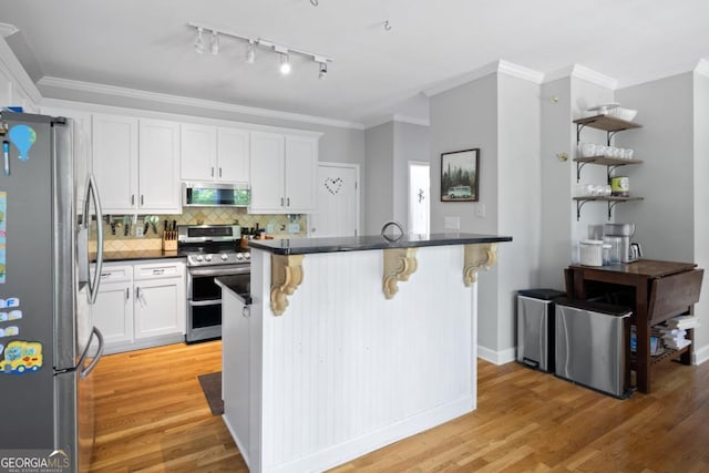 4016 Upland Trce, Marietta, GA 30066 - kitchen featuring light wood-style floors, white cabinets, stainless steel appliances, a breakfast bar area, and backsplash