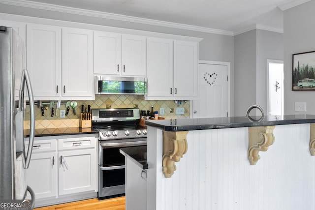 4016 Upland Trce, Marietta, GA 30066 - kitchen featuring decorative backsplash, white cabinetry, a breakfast bar area, and appliances with stainless steel finishes
