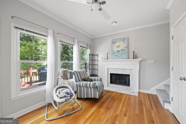 4016 Upland Trce, Marietta, GA 30066 - sitting room featuring a fireplace, light wood-type flooring, a ceiling fan, and ornamental molding