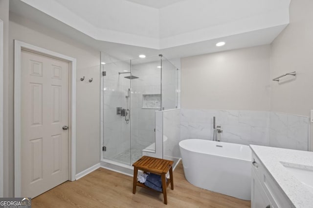 4016 Upland Trce, Marietta, GA 30066 - bathroom featuring a soaking tub, a stall shower, and wood finished floors