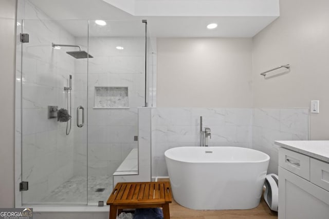 4016 Upland Trce, Marietta, GA 30066 - full bath featuring a wainscoted wall, a shower stall, a freestanding tub, and wood finished floors
