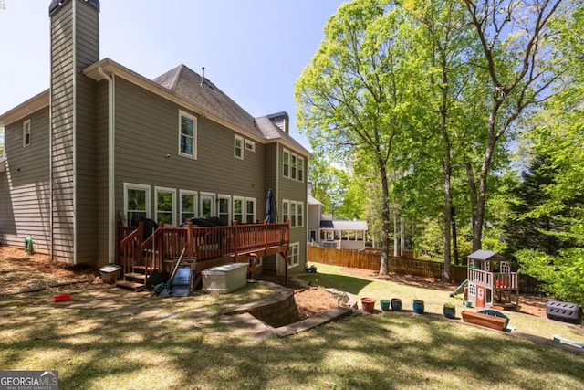 4016 Upland Trce, Marietta, GA 30066 - rear view of property featuring a deck, a lawn, a chimney, a playground, and fence