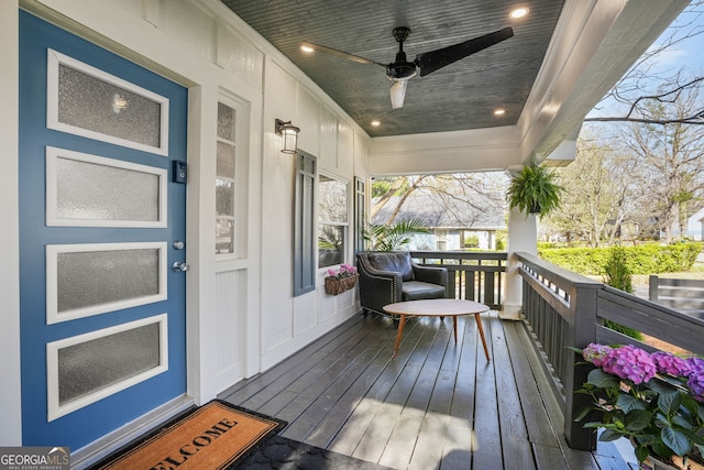 wooden terrace featuring covered porch and ceiling fan