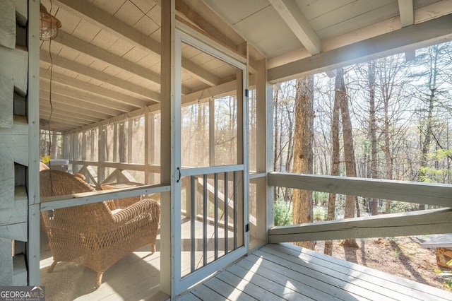 sunroom / solarium with beam ceiling and a healthy amount of sunlight