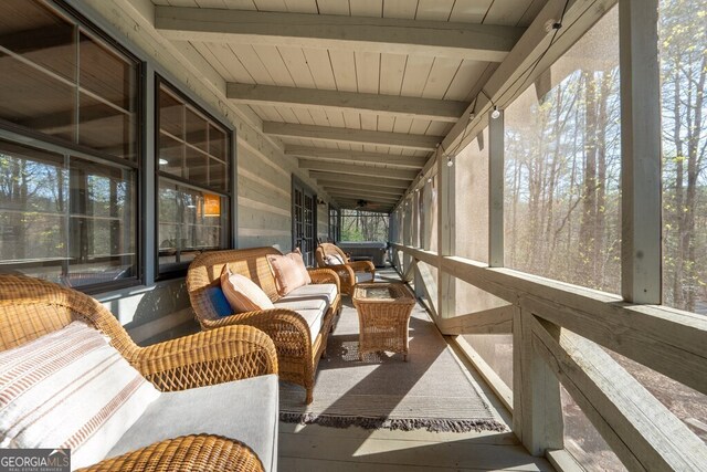 sunroom / solarium featuring an outdoor living space and beamed ceiling