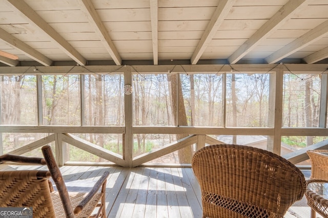 sunroom with a healthy amount of sunlight and beam ceiling
