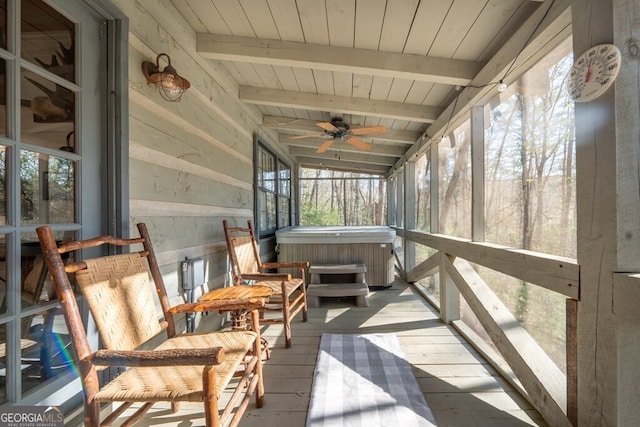 sunroom featuring beamed ceiling, a ceiling fan, and a healthy amount of sunlight
