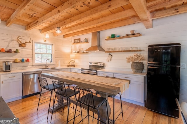 kitchen with open shelves, a sink, wall chimney range hood, appliances with stainless steel finishes, and wood ceiling