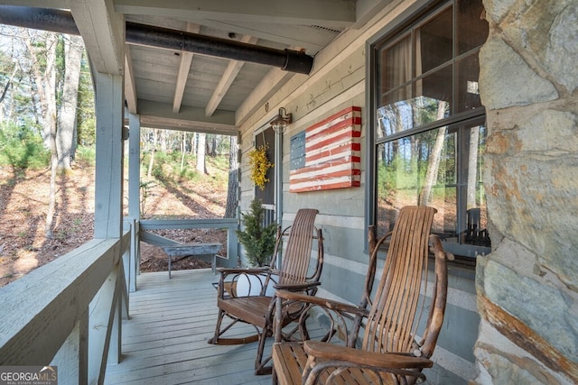 sunroom featuring beam ceiling and a wealth of natural light
