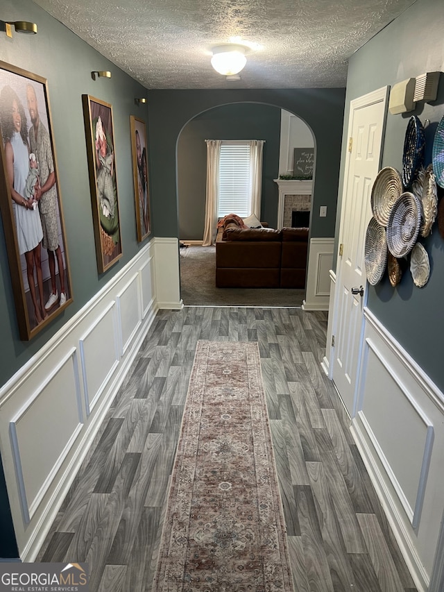 345 S Magnolia Walk SE, Atlanta, GA 30349 - corridor featuring arched walkways, wood finished floors, a textured ceiling, and a decorative wall