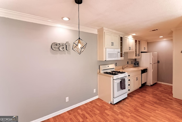 1181 Church St Unit D, Decatur, GA 30030 - kitchen with white appliances, light wood finished floors, crown molding, white cabinetry, and light countertops
