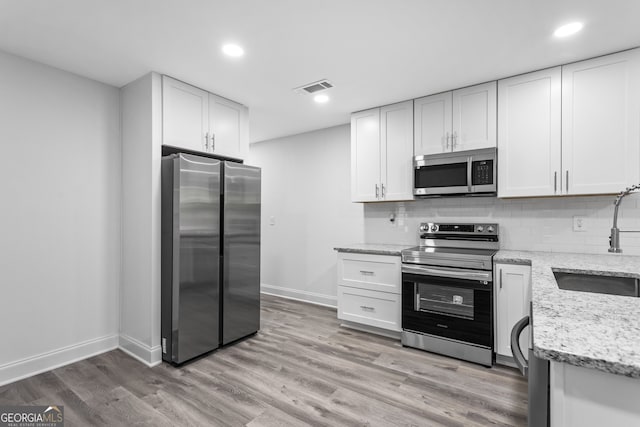 849 Wood St NW, Atlanta, GA 30318 - kitchen with stainless steel appliances, visible vents, a sink, and backsplash