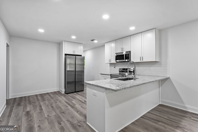 849 Wood St NW, Atlanta, GA 30318 - kitchen featuring appliances with stainless steel finishes, wood finished floors, a sink, and white cabinetry