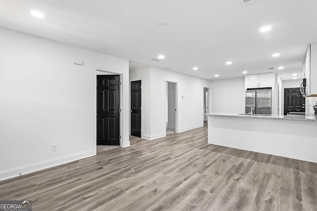 849 Wood St NW, Atlanta, GA 30318 - unfurnished living room featuring recessed lighting, light wood-type flooring, and baseboards
