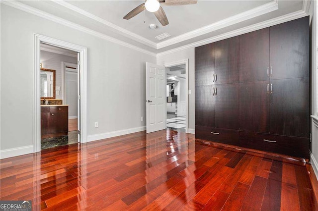 bedroom featuring baseboards, ornamental molding, wood finished floors, and visible vents