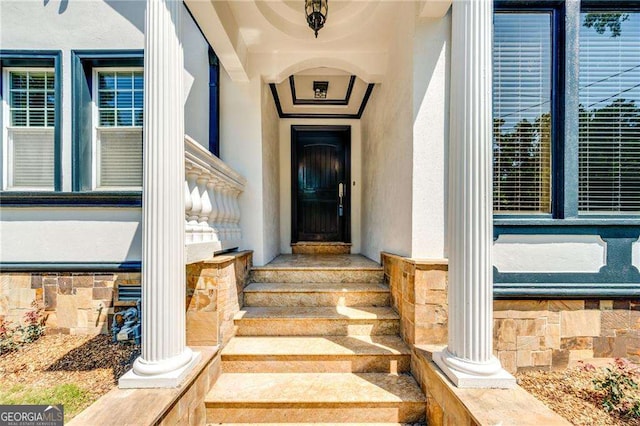 doorway to property featuring stucco siding