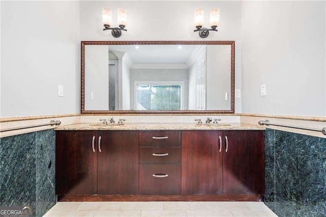 full bathroom featuring ornamental molding, a wainscoted wall, a sink, and double vanity