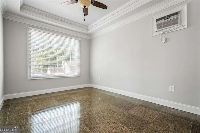 spare room with an AC wall unit, granite finish floor, baseboards, a ceiling fan, and ornamental molding