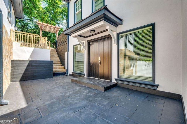 doorway to property featuring a patio area and stucco siding