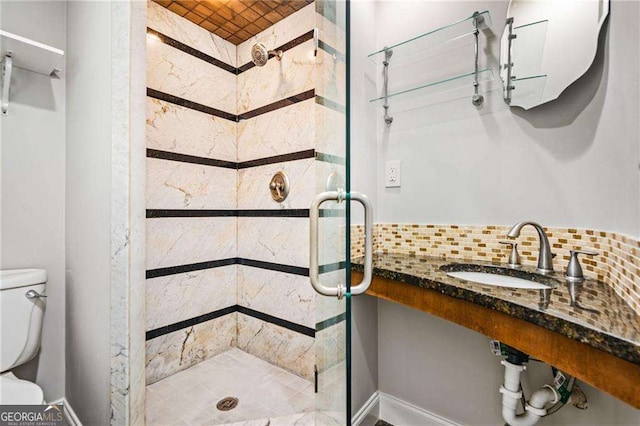 full bath featuring a shower stall, backsplash, toilet, and a sink