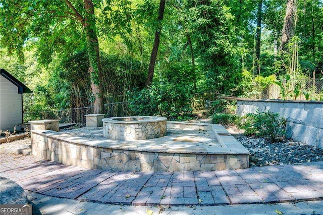exterior space featuring a fire pit, fence, and a patio area